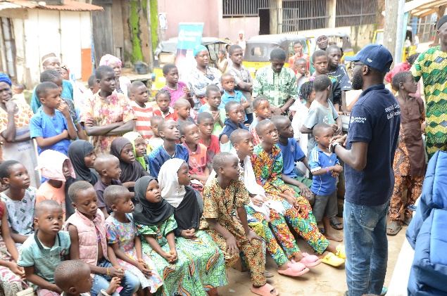 A large gathering of children and parents at a TWF community awareness campaign in a Nigerian neighbourhood.
